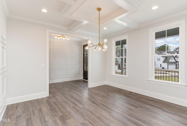 empty room featuring visible vents, baseboards, wood finished floors, and crown molding