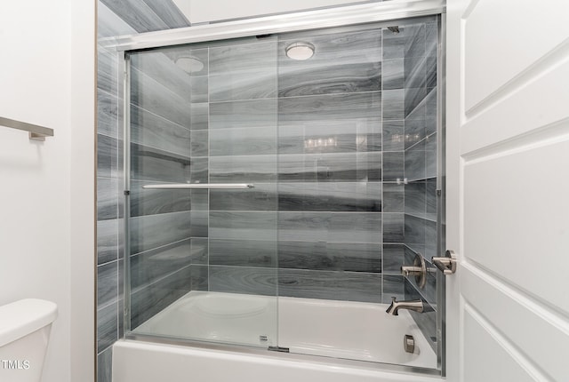 bathroom featuring enclosed tub / shower combo and toilet