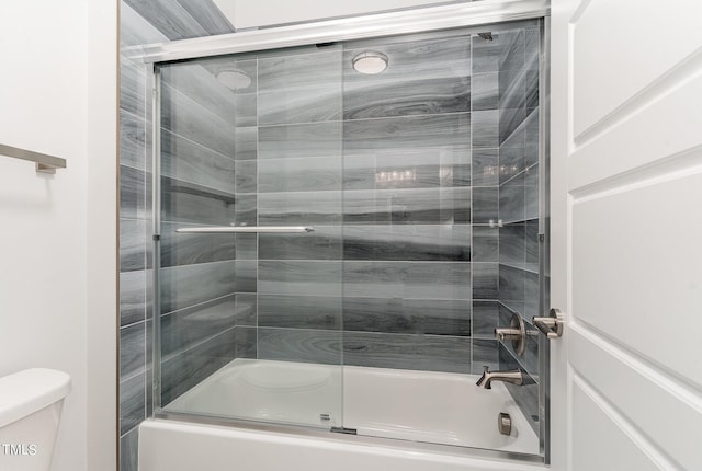 full bath featuring bath / shower combo with glass door and toilet