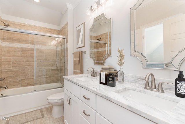 full bathroom featuring shower / bath combination with glass door, crown molding, vanity, and toilet