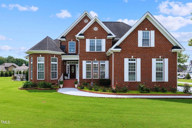 view of front of property with brick siding, a front lawn, and roof with shingles