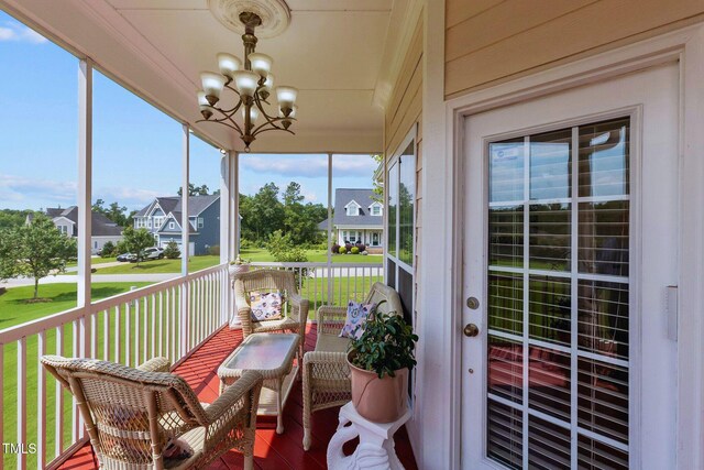 sunroom / solarium with a notable chandelier