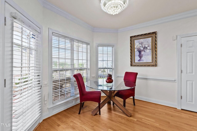 dining area featuring baseboards, light wood finished floors, and crown molding