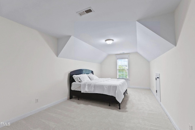 bedroom featuring light carpet, baseboards, visible vents, and vaulted ceiling