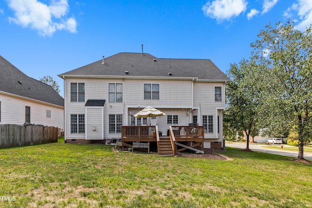 rear view of property with a yard and a deck