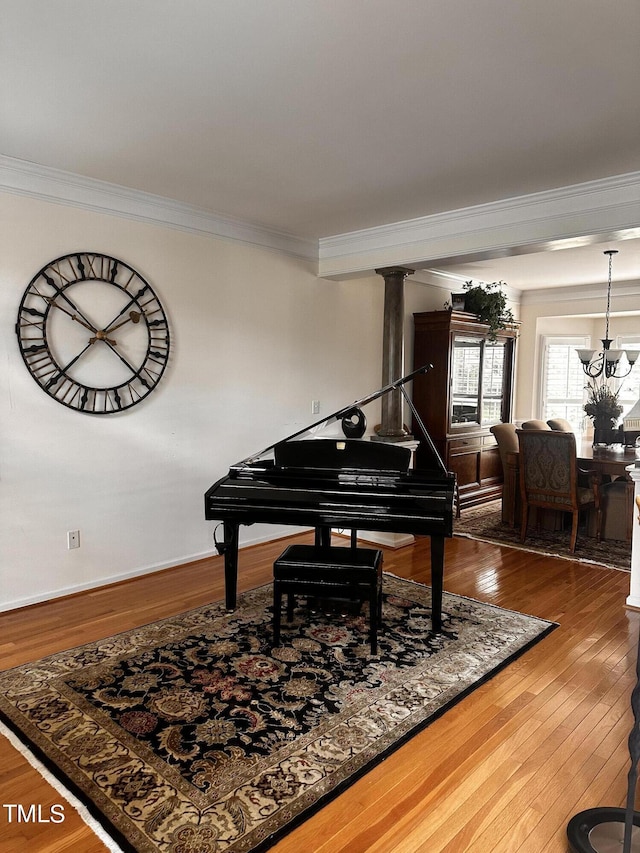 miscellaneous room with ornamental molding, a notable chandelier, and wood-type flooring