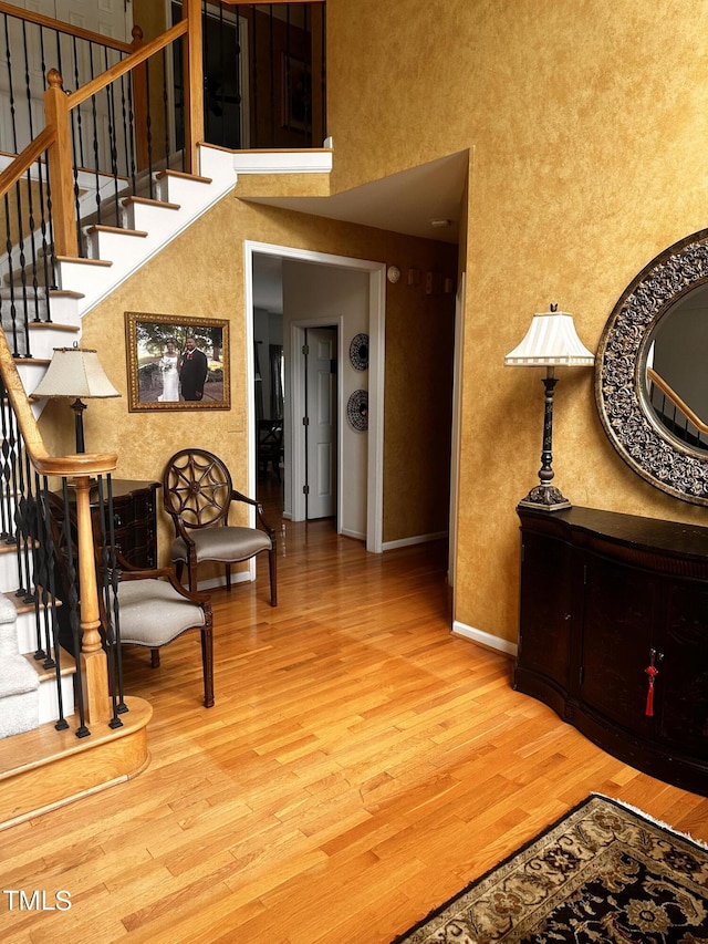 interior space featuring a high ceiling and hardwood / wood-style flooring