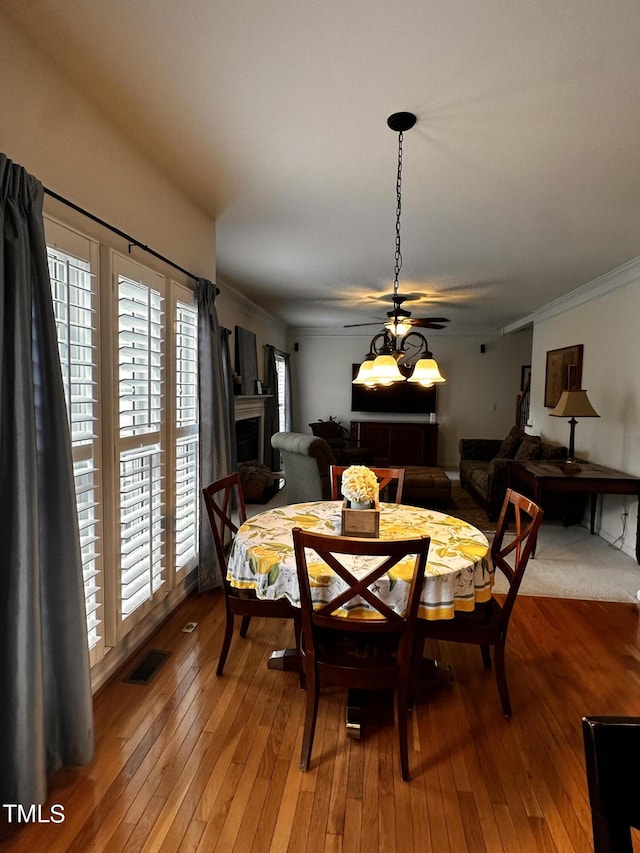 dining room with crown molding, ceiling fan, and hardwood / wood-style flooring