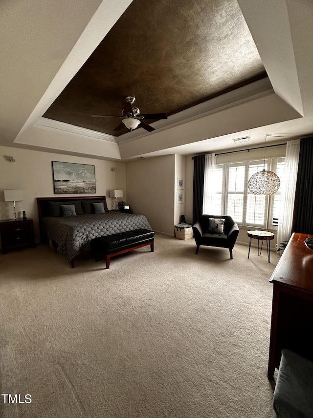 carpeted bedroom with a tray ceiling, a textured ceiling, and ceiling fan