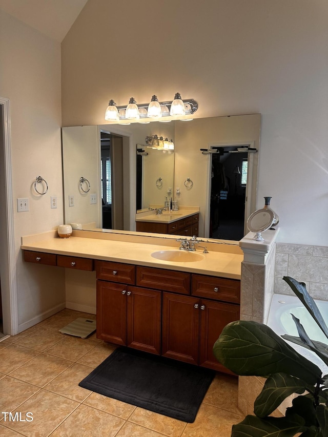 bathroom featuring tile patterned flooring, vaulted ceiling, a bathing tub, and vanity