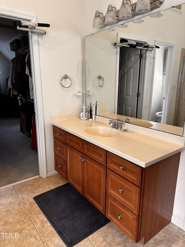 bathroom featuring tile patterned flooring, vanity, and toilet