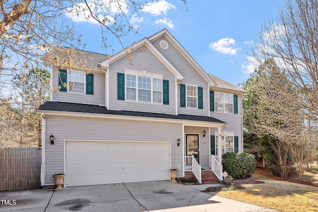 traditional-style home featuring an attached garage, fence, and concrete driveway