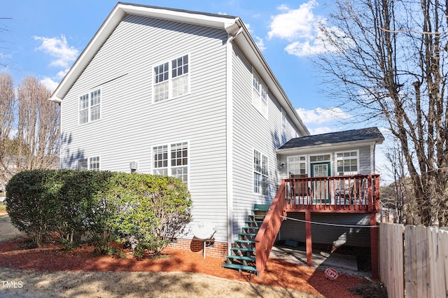 view of home's exterior featuring crawl space, stairway, a wooden deck, and fence