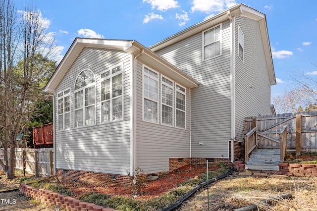 view of property exterior featuring crawl space, fence, and a gate