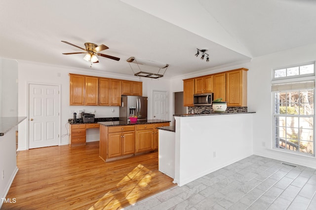 kitchen featuring tasteful backsplash, visible vents, light wood-style flooring, appliances with stainless steel finishes, and ceiling fan