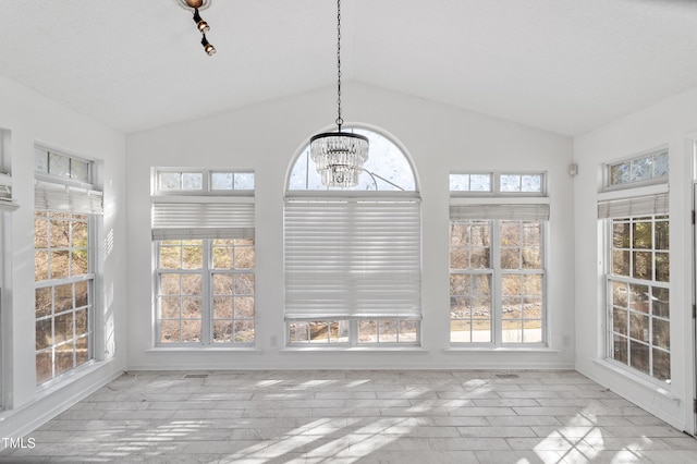 unfurnished sunroom featuring a chandelier, lofted ceiling, and visible vents