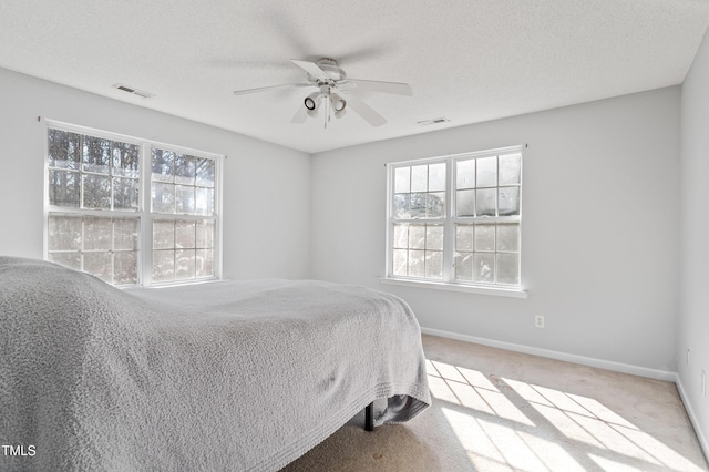 bedroom featuring baseboards, multiple windows, and visible vents