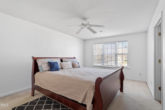 bedroom with light carpet, ceiling fan, baseboards, and a textured ceiling