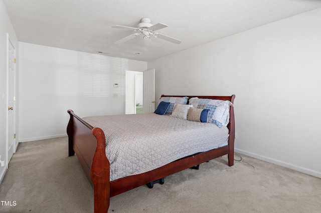 carpeted bedroom featuring ceiling fan, a textured ceiling, and baseboards