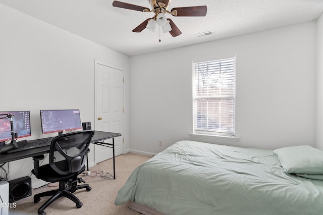 bedroom with a textured ceiling, carpet floors, a ceiling fan, and baseboards