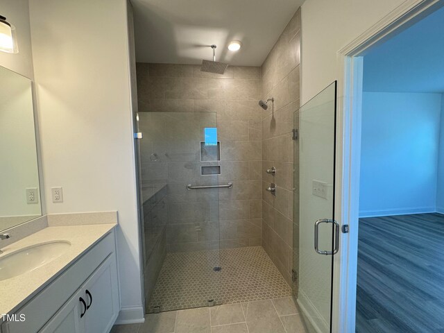 bathroom featuring a shower with door, vanity, and tile patterned floors