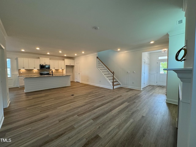 unfurnished living room featuring sink, crown molding, and dark hardwood / wood-style floors