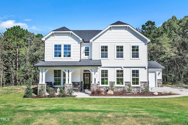 view of front of house featuring a front lawn, a garage, and covered porch