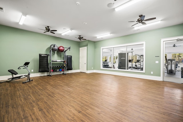 exercise room with wood finished floors, visible vents, and ceiling fan