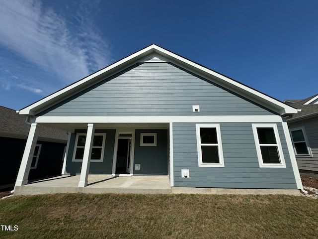 rear view of house with a lawn and a patio