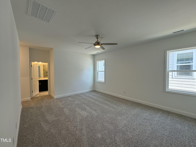 unfurnished room featuring baseboards, a ceiling fan, visible vents, and light carpet