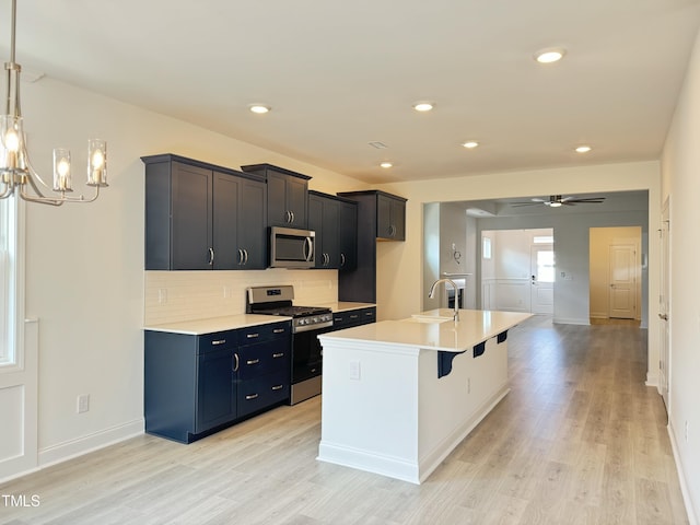 kitchen featuring a sink, decorative backsplash, appliances with stainless steel finishes, and light countertops