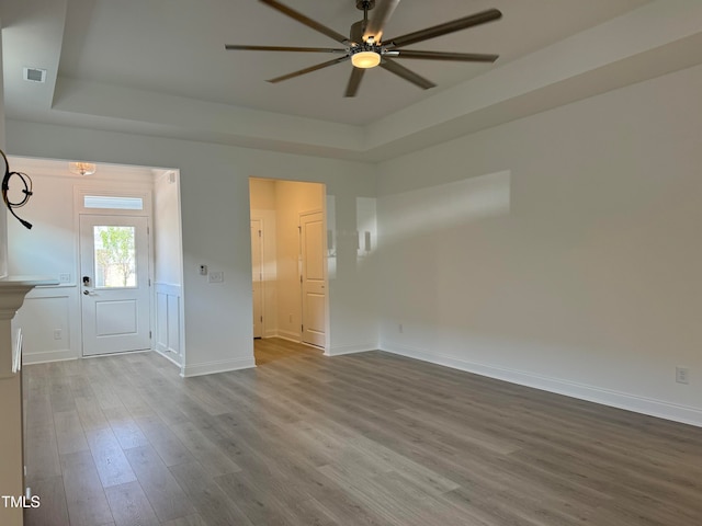 spare room featuring hardwood / wood-style flooring, a tray ceiling, and ceiling fan