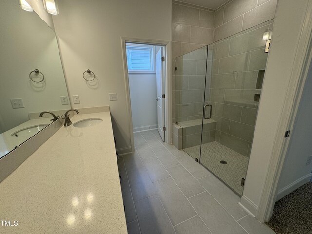 bathroom featuring tile patterned flooring, a shower with door, and vanity