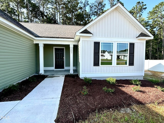 view of exterior entry featuring covered porch