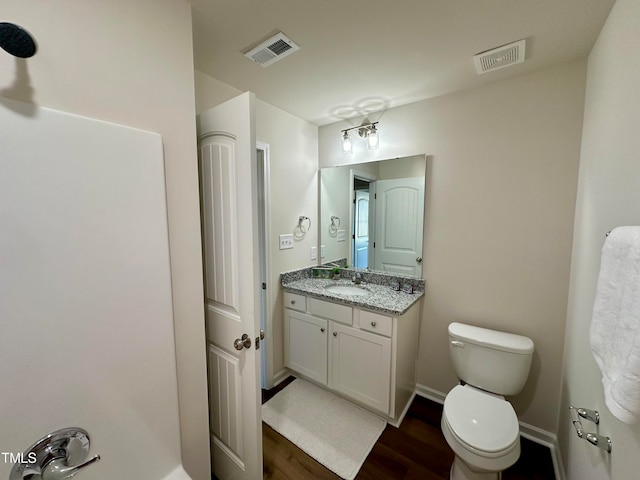 bathroom with hardwood / wood-style flooring, vanity, and toilet