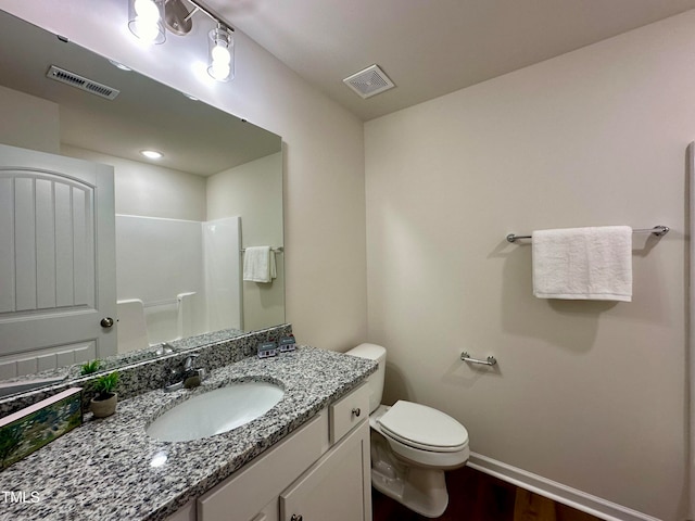 bathroom with vanity, hardwood / wood-style flooring, a shower, and toilet