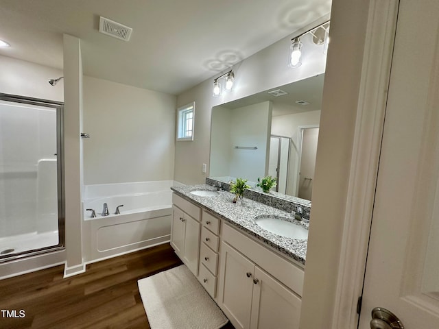 bathroom with independent shower and bath, vanity, and hardwood / wood-style flooring