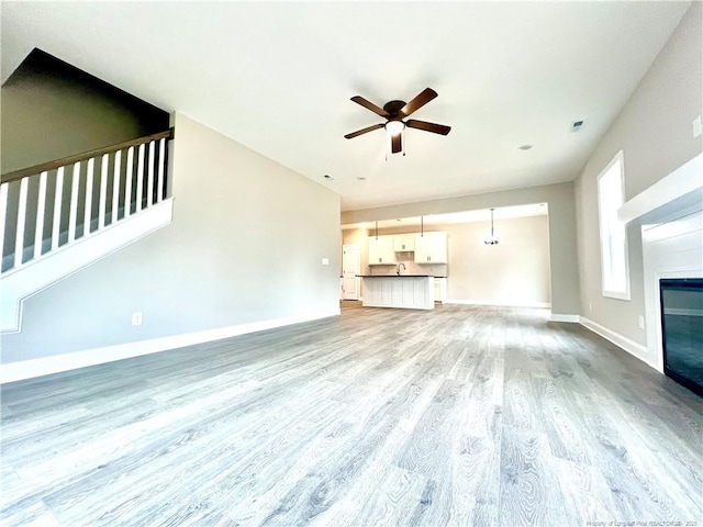 unfurnished living room featuring light hardwood / wood-style floors and ceiling fan