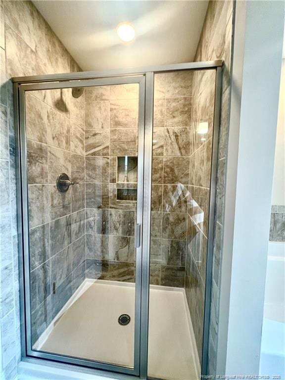 bathroom featuring a shower with door