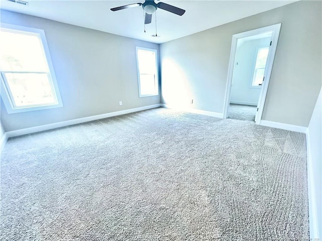 carpeted spare room featuring ceiling fan