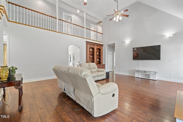 living area featuring baseboards, arched walkways, and hardwood / wood-style floors