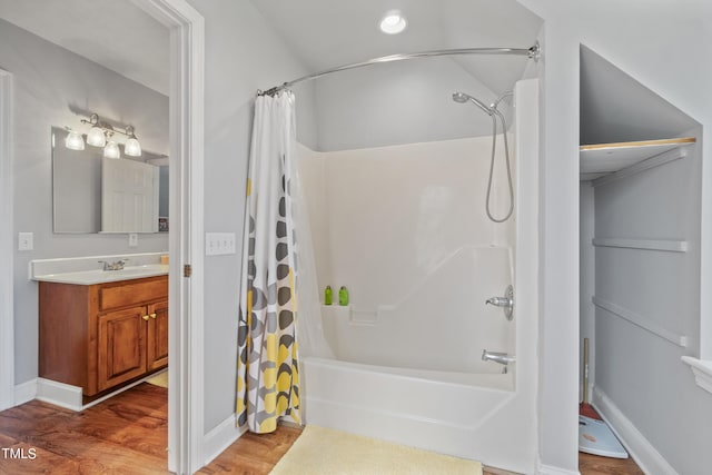 full bathroom with baseboards, wood finished floors, vanity, and shower / tub combo with curtain