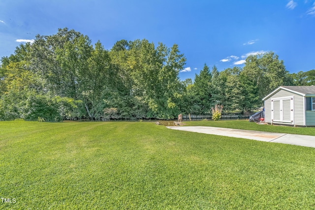 view of yard with driveway and an outdoor structure