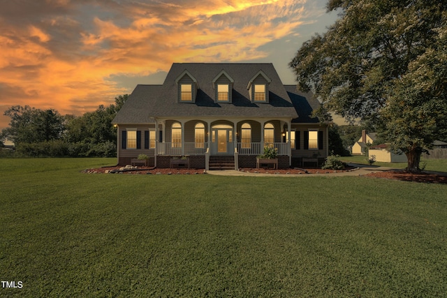 cape cod home with a porch, crawl space, a lawn, and a shingled roof