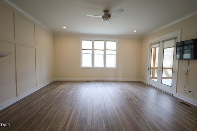 empty room featuring plenty of natural light, dark wood-type flooring, and ornamental molding