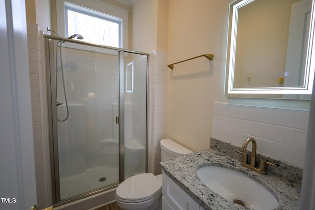 bathroom featuring tasteful backsplash, vanity, walk in shower, and toilet