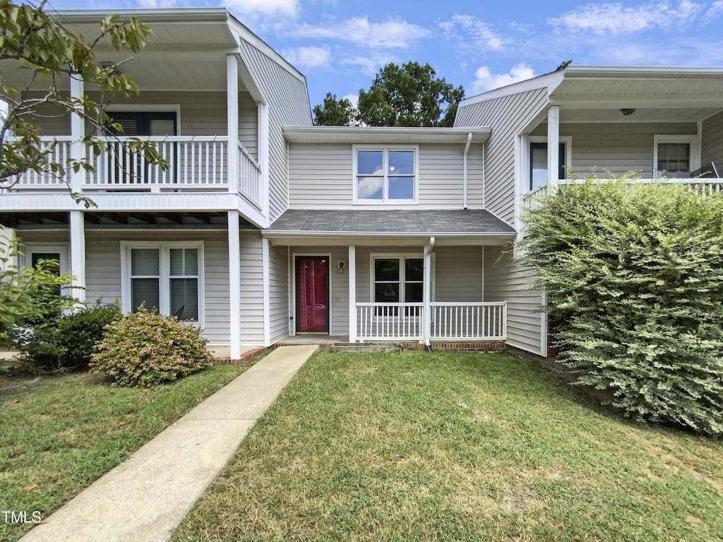 townhome / multi-family property featuring a front yard and covered porch