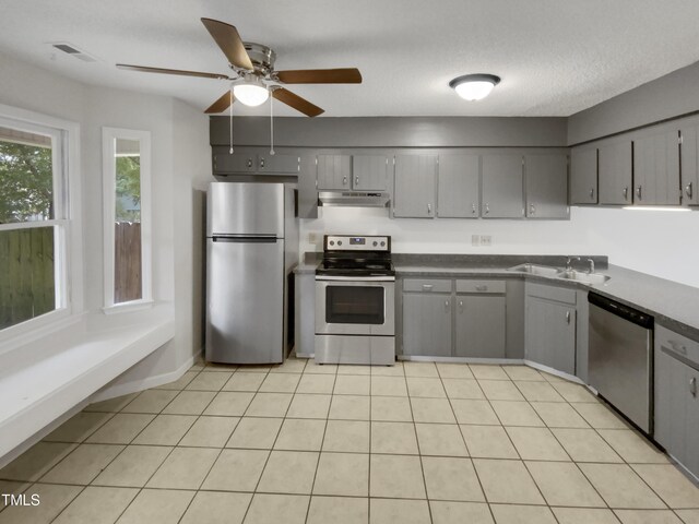 kitchen featuring sink, stainless steel appliances, light tile patterned floors, and gray cabinets