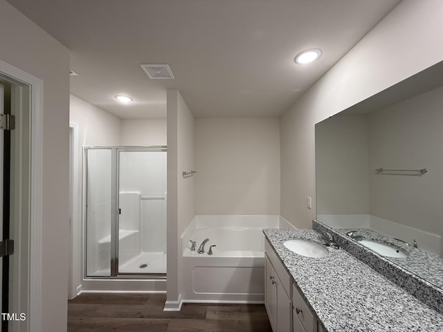 bathroom with wood-type flooring, vanity, and shower with separate bathtub