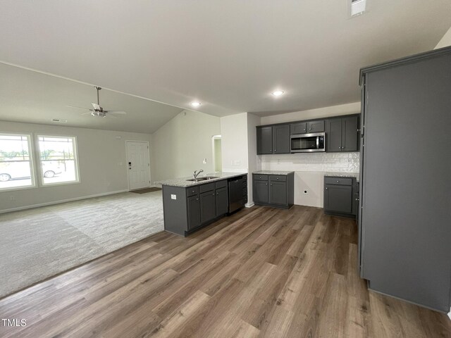 kitchen featuring ceiling fan, sink, kitchen peninsula, dark wood-type flooring, and gray cabinets